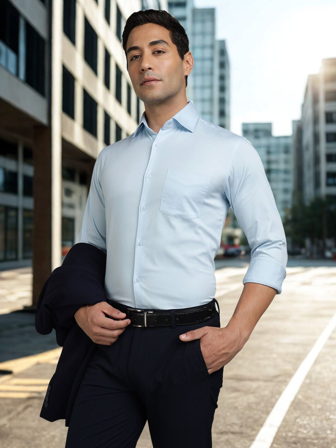 Man wearing a light blue dress shirt and dark pants in an urban setting