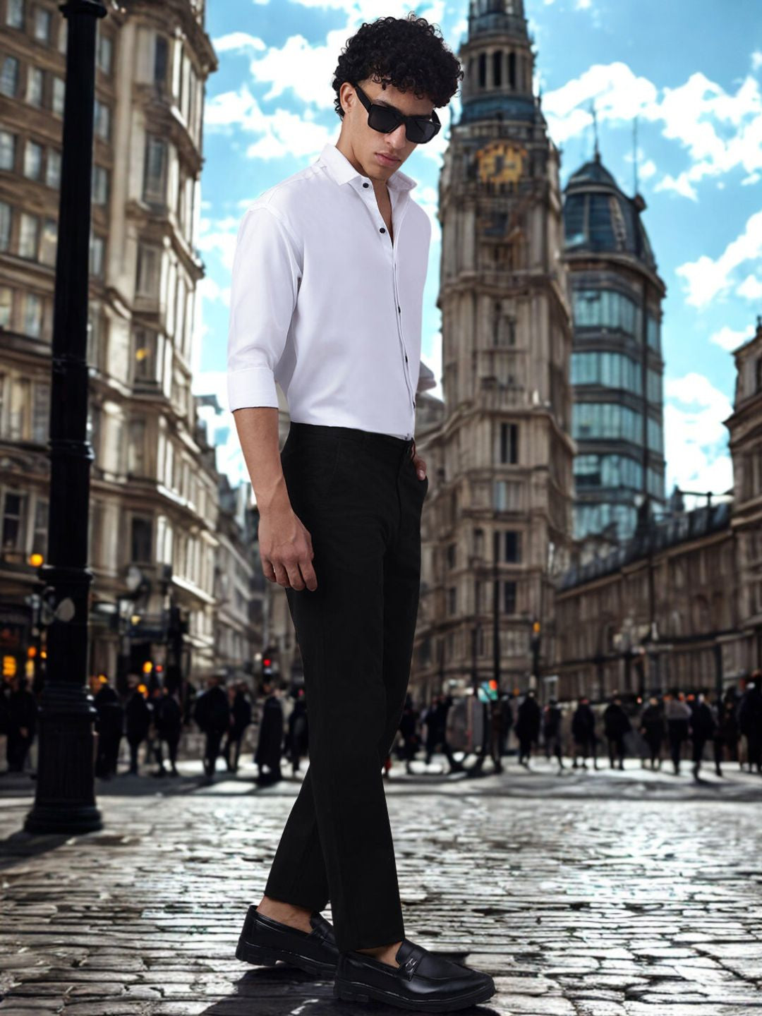 Person wearing a white shirt and black pants in front of a cityscape with a clock tower.