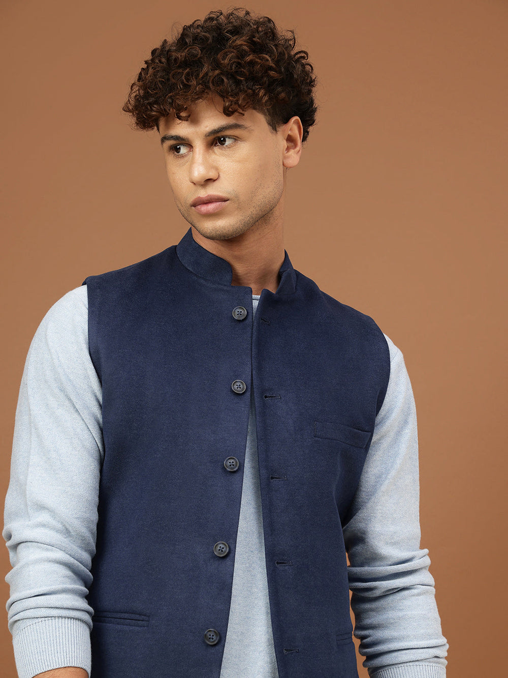 Man wearing a navy blue Nehru jacket with a mandarin collar over a light grey shirt