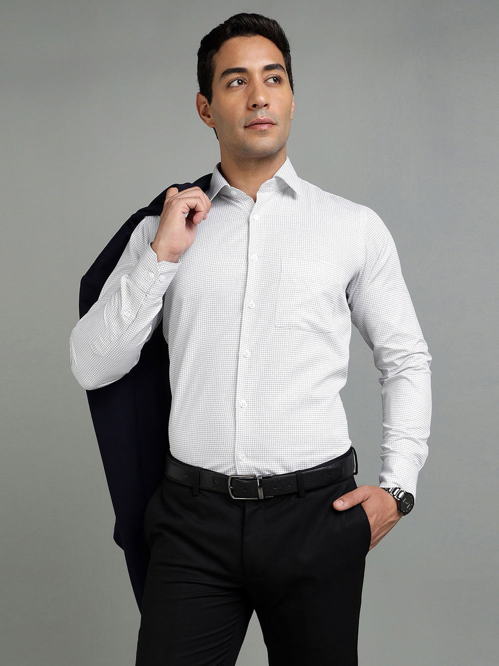 Man wearing a white dress shirt and black pants against a gray background