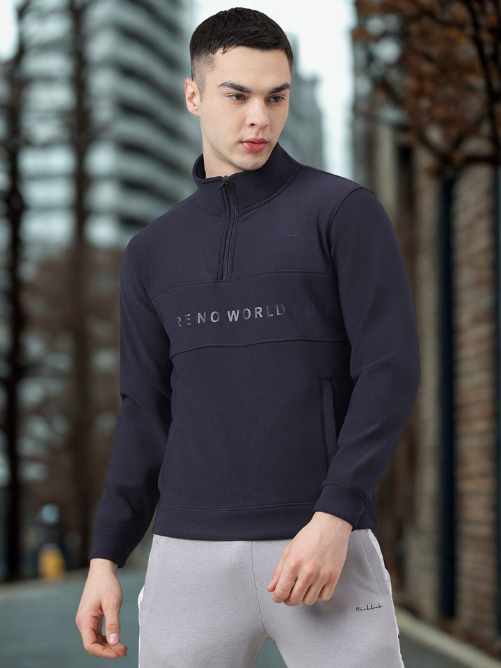 Man wearing a navy blue pullover with 'FEND WORLD' logo in an urban setting